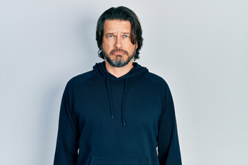 Middle age caucasian man wearing casual sweatshirt depressed and worry for distress, crying angry and afraid. sad expression.