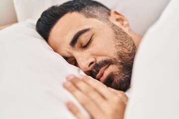 Fototapeta na wymiar Young hispanic man lying on bed sleeping at bedroom