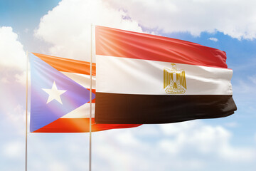 Sunny blue sky and flags of egypt and puerto rico