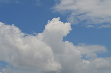 Fototapeta na wymiar Large puffy white clouds on clear blue sky 