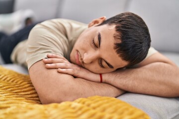 Obraz na płótnie Canvas Young man lying on sofa sleeping at home