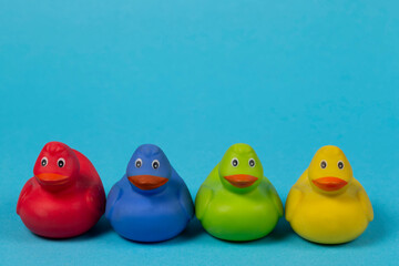 Multi-colored rubber ducks on a blue background.