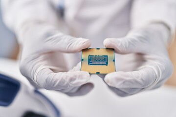 African american woman wearing scientist uniform holding cpu microchip at laboratory