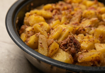 Braised pork with potatoes and onions on a brown wood. Composition with vegetables. Place to copy. Place for text. Fried potato recipe.