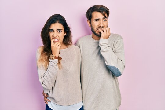 Young hispanic couple wearing casual clothes looking stressed and nervous with hands on mouth biting nails. anxiety problem.
