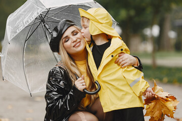 Funny kids in rain boots playing in a rain park