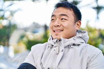 Young chinese man smiling confident standing at park