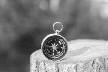 black and white photo of round compass as symbol of tourism with compass, travel with compass and outdoor activities with compass