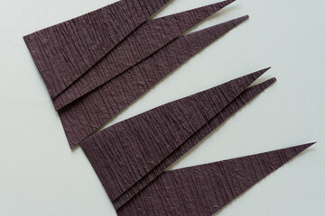 brown paper triangles arranged on a paper background