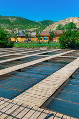 fish farm in a mountain valley with aquaculture cages and wooden buildings