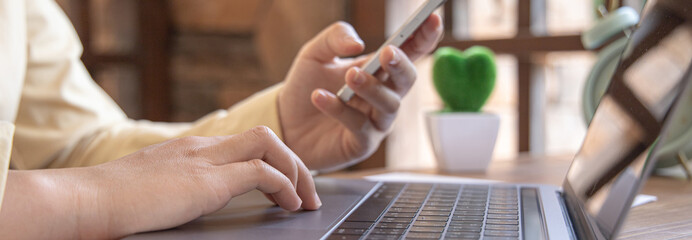 Finance workers are reviewing the company's financial data on a laptop and using smartphones to communicate or chat with the team at social distances, Working during the virus outbreak.