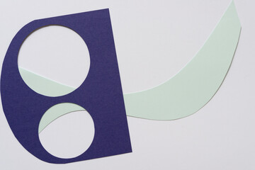 purple paper stencil with two circles and wavy blue green shape