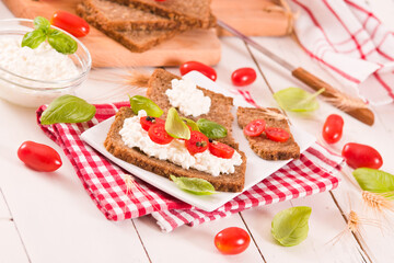 Rye bread with cottage cheese, basil and tomato.