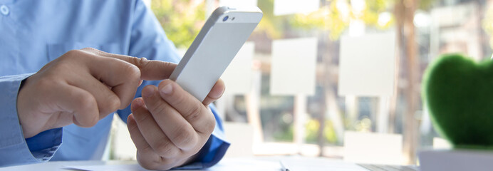 Finance workers are reviewing the company's financial data on a laptop and using smartphones to communicate or chat with the team at social distances, Working during the virus outbreak.