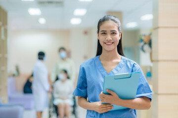 Portrait of Asian female nurse wearing uniform working in hospital with doctor and patient sitting...