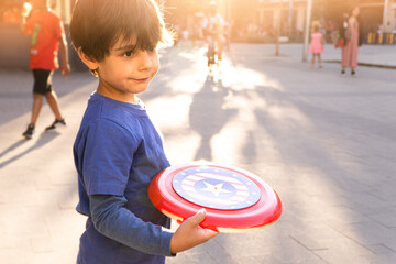 Latin boy with american flag frisbee playing on the street