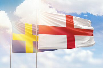 Sunny blue sky and flags of england and sweden