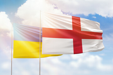 Sunny blue sky and flags of england and ukraine