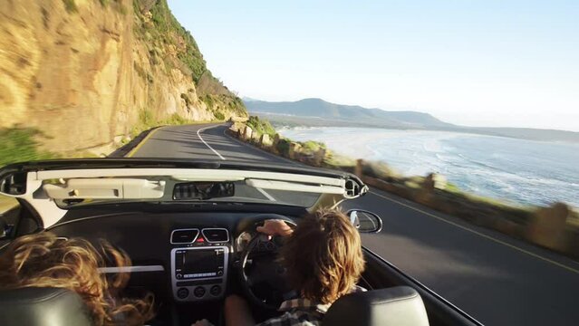 Young couple in love enjoying a roadtrip in their convertible