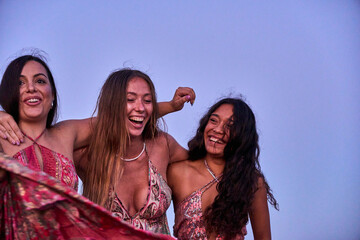 group of three young interracial friends enjoying a walk on the beach on a summer afternoon