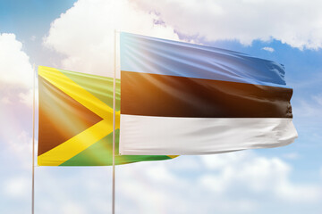 Sunny blue sky and flags of estonia and jamaica