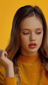 pensive teenager isolated on yellow
