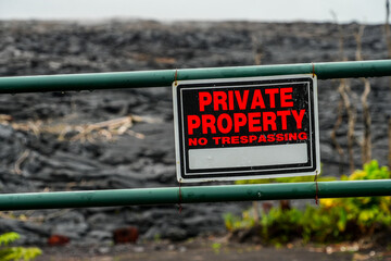 "Private property" sign on a lava field in the Leilani Estates destroyed by the volcanic eruption of the Fissure 8 in the southeast of Big Island near Hilo in Hawaii, USA