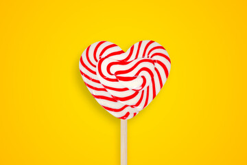 heart shaped lollipop on yellow background