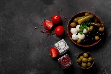 Products for cooking pizza and salad on a dark background. Fresh vegetables, sauces and herbs with spices.