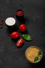 Products for cooking pizza and salad on a dark background. Fresh vegetables, sauces and herbs with spices.
