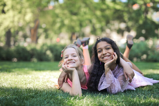 two little girls hugging smiling in a park
