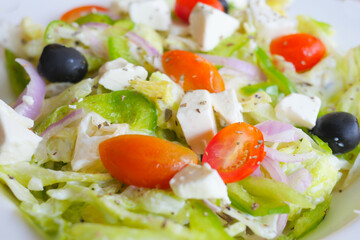 Close up of greek salad in a bowl on table.