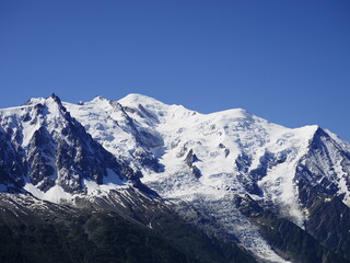 mont blanc dans les alpes, avec ciel bleu, neige, rocs et pics.