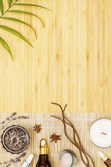 Self care, spa, relax composition with natural oils, candles and aroma sticks on a wooden background with palm leaf and copy space. Depression treatment and mental health care with natural remedies