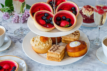 Selection of gourmet cakes with coffee and sparkling wine on a table