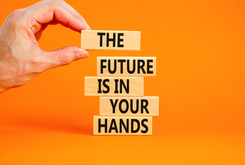 The future is in your hands symbol. Concept words The future is in your hands on wooden blocks on a beautiful orange table orange background. Businessman hand. Business future in your hands concept.