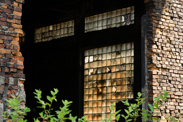 Damaged and dusty luxfers in a window of an abandoned industrial building