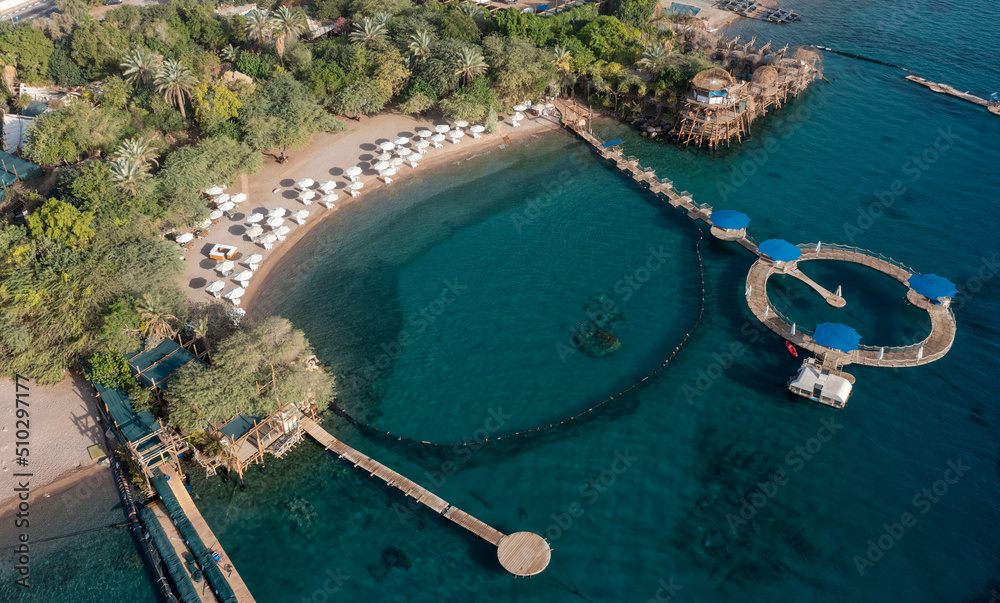 Wall mural Dolphin Reef is a horseshoe-shaped sea-pen where bottlenose dolphins in the Gulf of Eilat in the northern-eastern Red Sea near the city of Eilat in southern Israel swim in and out of top view