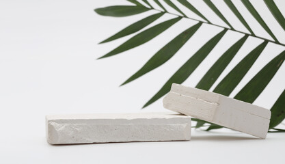 Stack stones platform podium and palm leaf on gray light copy spase background. Minimal empty display product presentation scene.