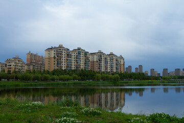 Fototapeta na wymiar Changchun, Jilin - June 3 2021: Modern apartment building by a city park in summer.