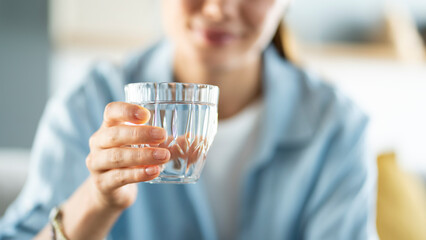 Young woman drinks a glass of water