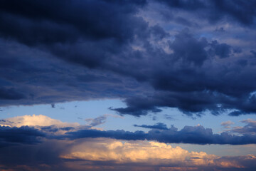 Naklejka na ściany i meble Thunderstorm dramatic clouds during evening sunset.