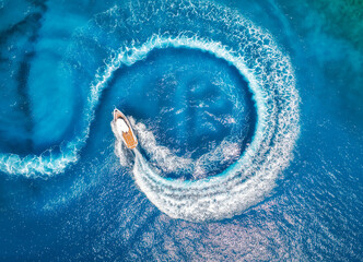 Aerial view of the speed boat in clear blue water at sunset in summer. Top view from drone of fast floating yacht in mediterranean sea. Travel in Oludeniz, Turkey. Tropical landscape with motorboat - obrazy, fototapety, plakaty