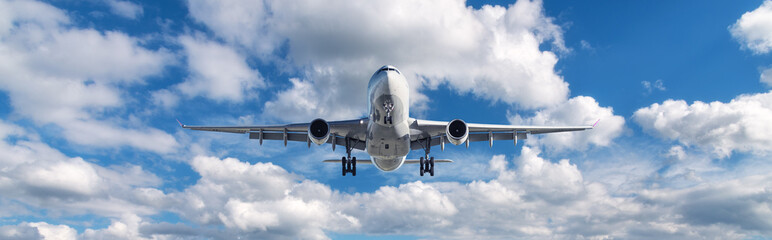 Airplane is flying in clouds at sunny day in summer. Landscape with passenger airplane, blurred...