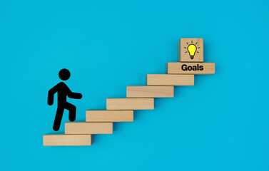 Stickman climbing stairs made by wooden blocks with the target icon at the top. goals concept, achievement or business progress goal concept.	