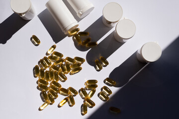 Yellow pills on white background, pill packings in the background. Lots of medication. Top view of Fish oil gel capsules isolated on white background. Salmon fish capsules view. Omega 3. Supplementary