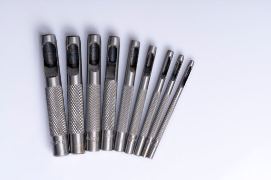 Macro detail of a set of steel punches isolated on white