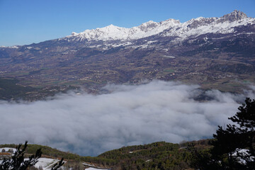 fog lifting over serre ponçon lake in the mountains of the alps france