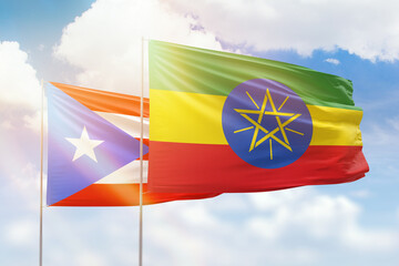Sunny blue sky and flags of ethiopia and puerto rico