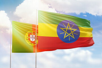 Sunny blue sky and flags of ethiopia and portugal